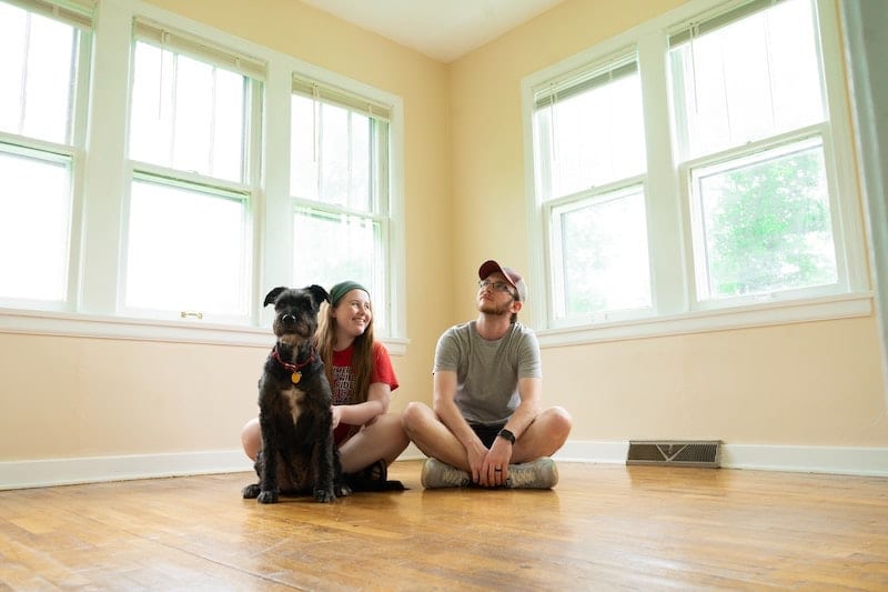 young couple on floor of new house with dog